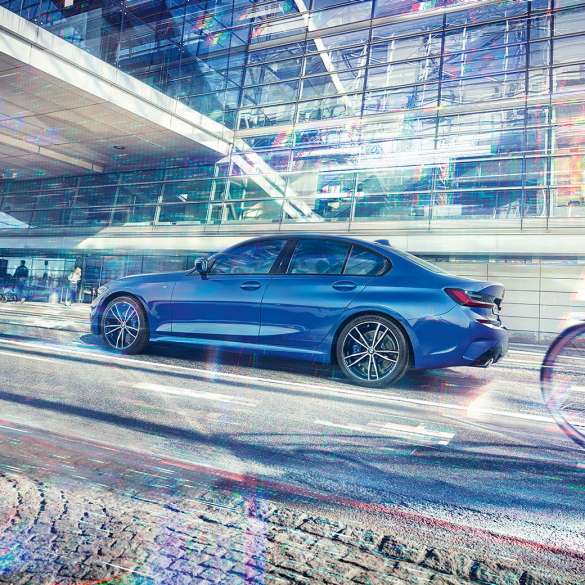 BMW 3-serie Sedan sett fra siden. BMW 3-serie Sedan sett fra siden stående under glassbygning om dagen.