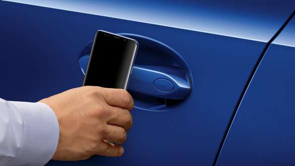 BMW 3-serie Sedan digital BMW nøkkel. Nærbilde av en Samsung-telefon som holdes foran dørhåndtaket på førerdøren på BMW 3-serie Sedan.