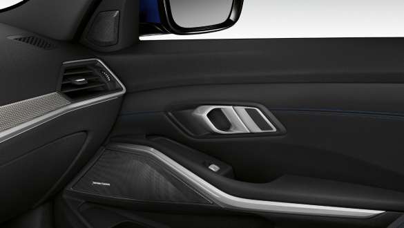 BMW 3-serie Sedan med Harman Kardon surroundlydsystem. Nærbilde av innsiden av belyst fordør på passasjersiden med høyttaler i Harman Kardon surroundlydsystemet.