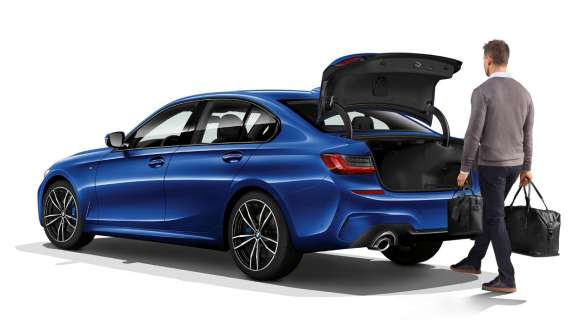 BMW 3-serie Sedan (G20), automatisk baklukebetjening BMW 3-serie Sedan (G20) sett på skrått bakfra med fører, som åpner bakluken automatisk med foten.