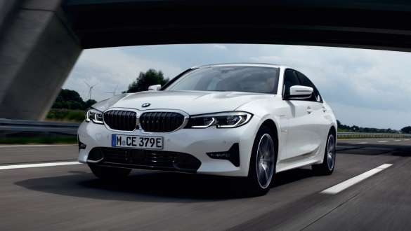 Plug-in-hybrid BMW 3-serie Sedan 2021 G20 sett på skrå forfra kjørende Plug-in-hybrid BMW 3-serie Sedan 2021 G20 sett på skrå forfra kjørende på vei