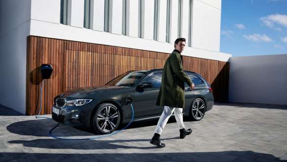 Plug-in hybrid BMW 3-serie Touring 2021 G21 sett på skrå fra siden ved lading Plug-in hybrid BMW 3-serie Touring 2021 G21 sett på skrå fra siden ved lading, med modell