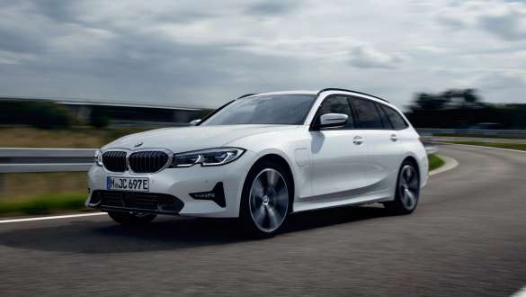 Plug-in hybrid BMW 3-serie Touring 2021 G21 sett på skrå forfra mens den kjører Plug-in hybrid BMW 3-serie Touring 2021 G21 sett på skrå forfra mens den kjører på vei