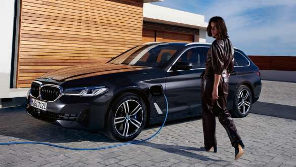 Plug-in hybrid BMW 5-serie Touring 2021 G31 LCI, sett skrått fra siden under lading Plug-in hybrid BMW 5-serie Touring 2021 G31 LCI, sett skrått fra siden under lading med modell