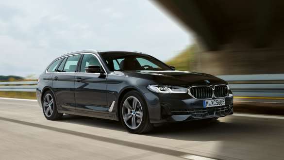 Plug-in hybrid BMW 5-serie Touring 2021 G321 LCI, sett skrått forfra mens den kjører Plug-in hybrid BMW 5-serie Touring 2021 G31 LCI, sett skrått forfra mens den kjører på vei