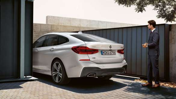 Fjernstyrt parkering BMW 6-serie Gran Turismo G32 Fjernstyrt parkering Mann parkerer sin BMW 6-serie Gran Turismo fjernstyrt G32 2017 mineralhvit metallic