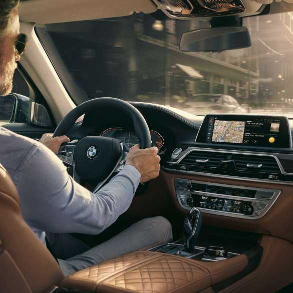 Connectivity-funksjoner i BMW 7-serie Sedan BMW 7-serie Sedan: Mann sitter i BMW og bruker Connectivity-funksjoner