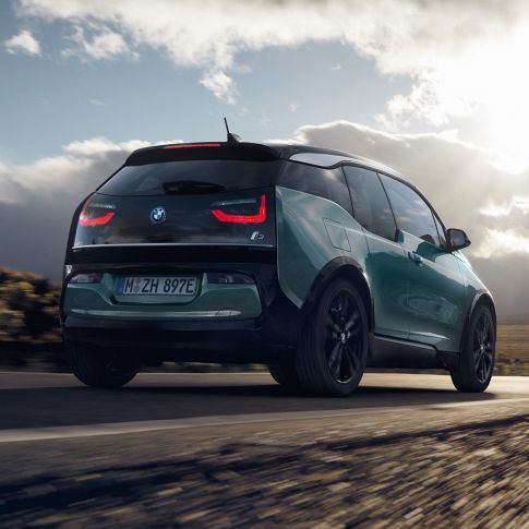 BMW i3 2018 Jucarobeige sett skrått bakfra kjørende på landevei BMW i3 I01 2018 Jucarobeige med detaljer i frostgrå metallic sett skrått bakfra kjørende på landevei