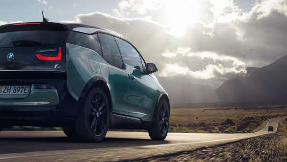 BMW i3 2018 sett skrått bakfra kjørende på landevei BMW i3 I01 2018 Jucarobeige med detaljer i frostgrå metallic sett skrått bakfra kjørende på landevei