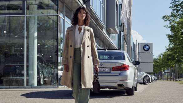 Kvinne foran BMW bilforretning BMW Service Inclusive kvinnen foran BMW-bilforretning