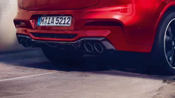 M sportseksosanlegg. Utvendig design på BMW X4 M Competition i torontorød metallic, M sportseksosanlegg og diffusor i karbonfiber sett bakfra.