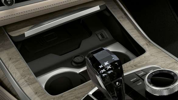 Koppholder med varme-/kjølefunksjon i BMW X7 M-modell BMW X7 M-modell, interiør, nærbilde av midtkonsollen med fokus på koppholderen med varme-/kjølefunksjon, G07