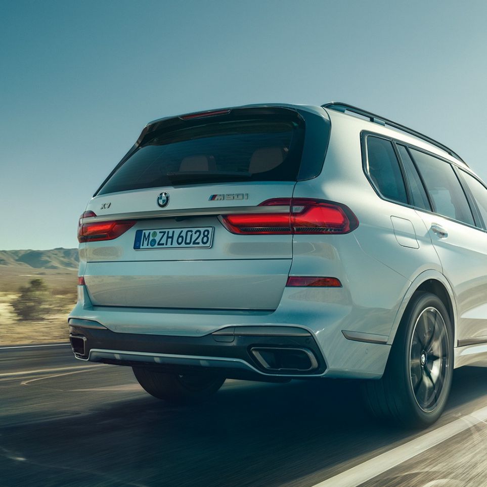 BMW X7 M50i sett bakfra BMW X7 M50i i mineralhvit, i fart, sett skrått bakfra, G07, 2019