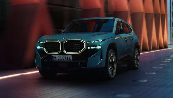 BMW XM G09 Plug-in-hybrid Sett fra siden BMW XM G09 Plug-in-hybrid Sett fra siden foran bygning