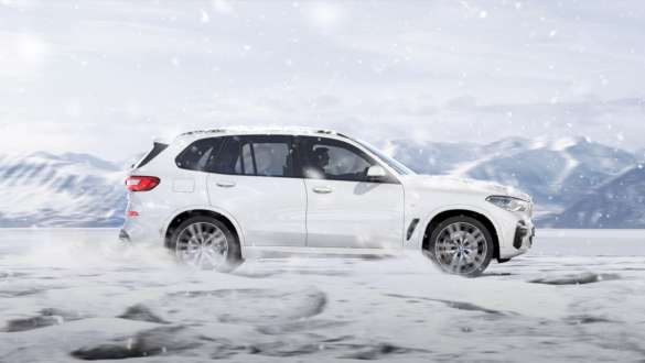 Kjøremodus xSnow BMW X5 Kjøremodus xSnow BMW X5 G05 2018 Mineralhvit metallic sett fra siden kjørende på snø