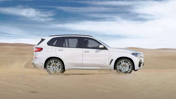 Kjøremodus xSand BMW X5 Kjøremodus xSand BMW X5 G05 2018 Mineralhvit metallic sett fra siden kjørende på sand