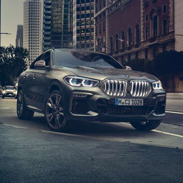 BMW X6 adaptivt M understell Professional. BMW X6 i frontperspektiv foran bylandskap.