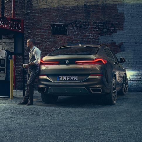 BMW X6 hekken. BMW X6 sett bakfra foran bylandskap.