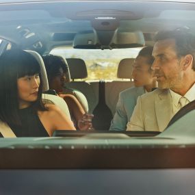 BMW Gesture Control En mann og en kvinne sitter i bilen, kvinnen bruker Gesture Control