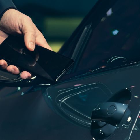 Digital nøkkel Digital nøkkel: en mann holder smarttelefonen mot bildøren fra utsiden