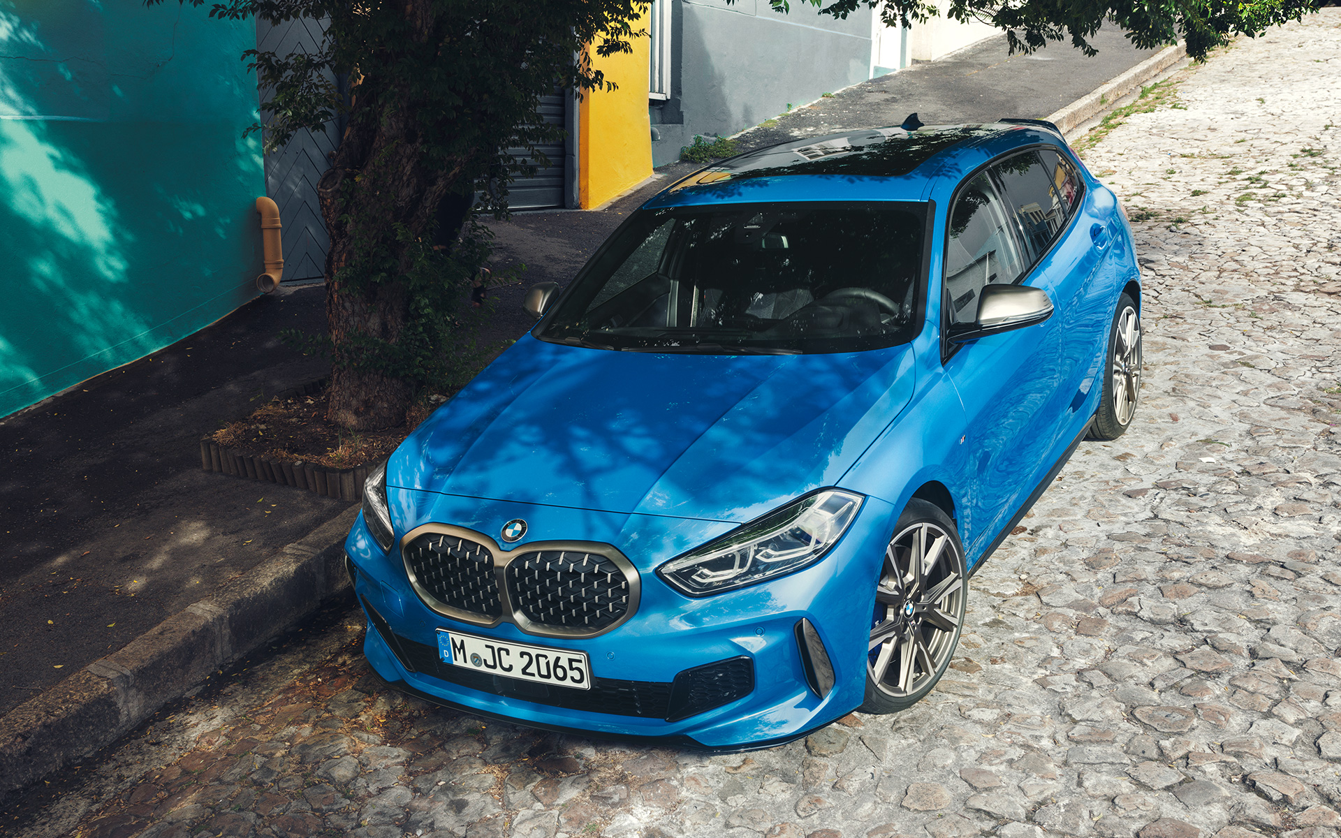 BMW 1-serie M135i F40 i Misano Blau metallic, sett skrått forfra i fugleperspektiv, parkert i veikanten