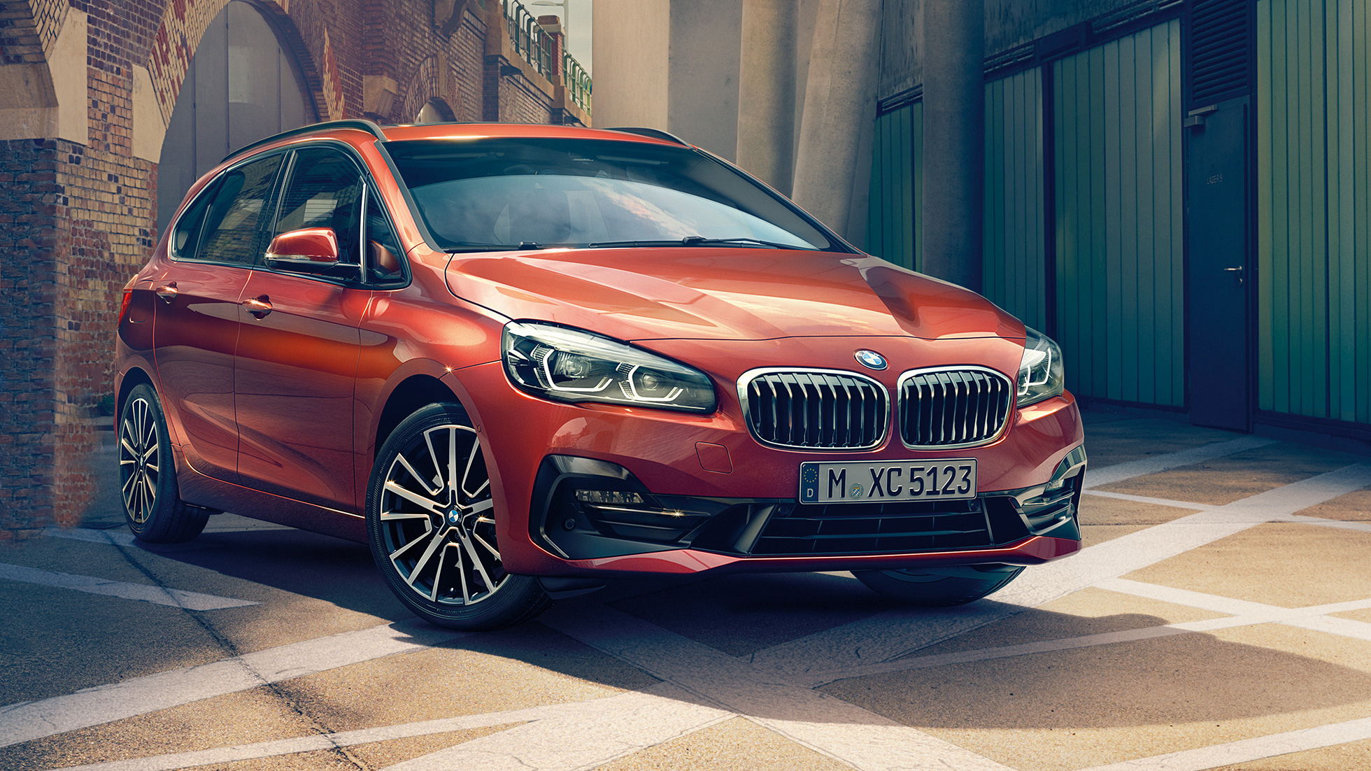 Eksteriør BMW 2-serie Active Tourer BMW 2-serie Active Tourer F45 Facelift 2018 Sunset Orange metallic Sett skrått forfra parkert i et smug