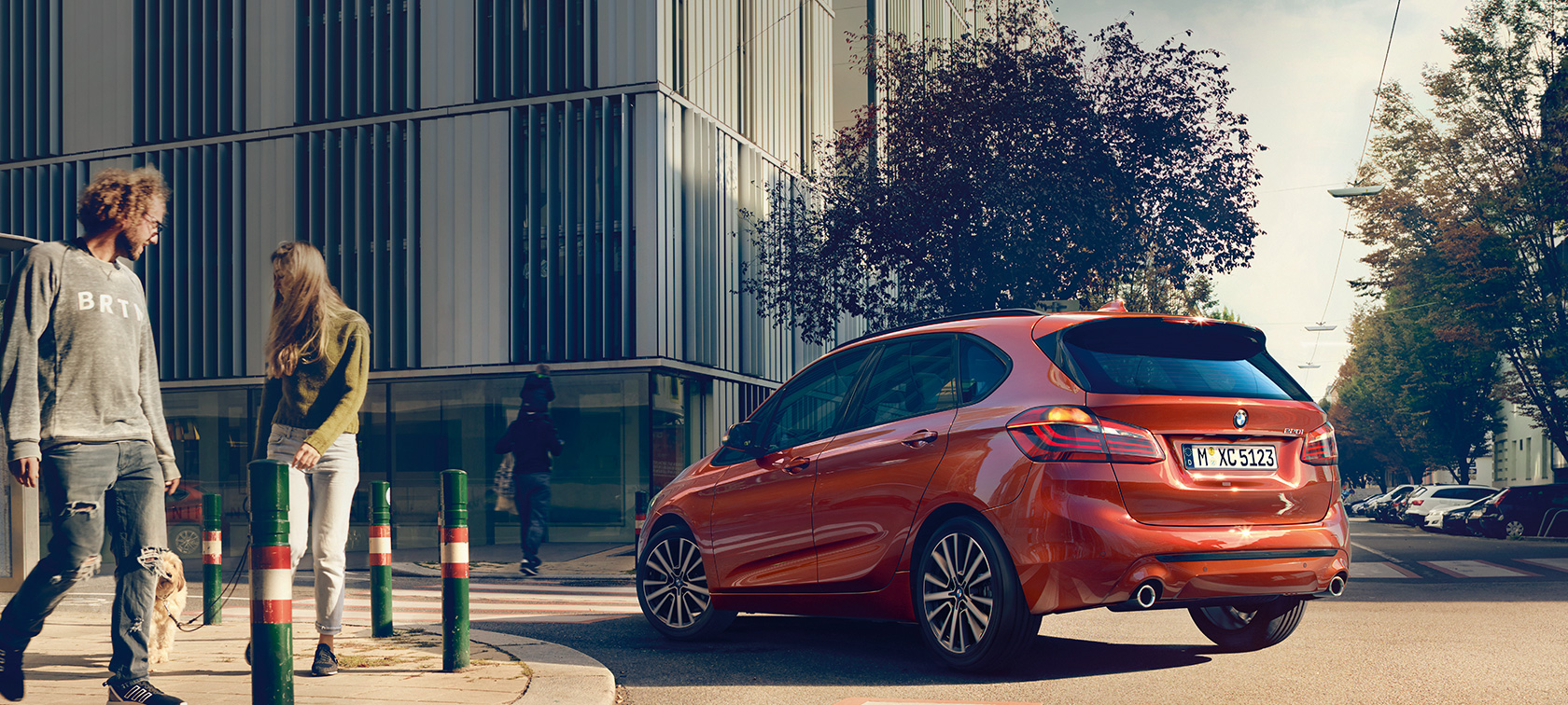 Sett skrått bakfra BMW 2-serie Active Tourer 220i BMW 2-serie Active Tourer F45 Facelift 2018 Sunset Orange metallic sett skrått bakfra kjørende på veien