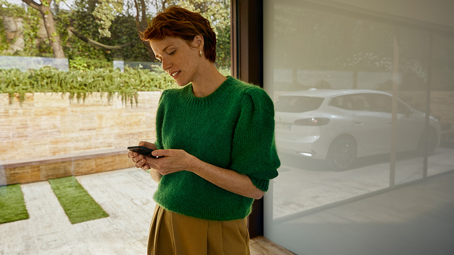 BMW Service Inclusive, Kvinne med smarttelefon i hånden Kvinne med smarttelefon i hånden BMW Service Inclusive