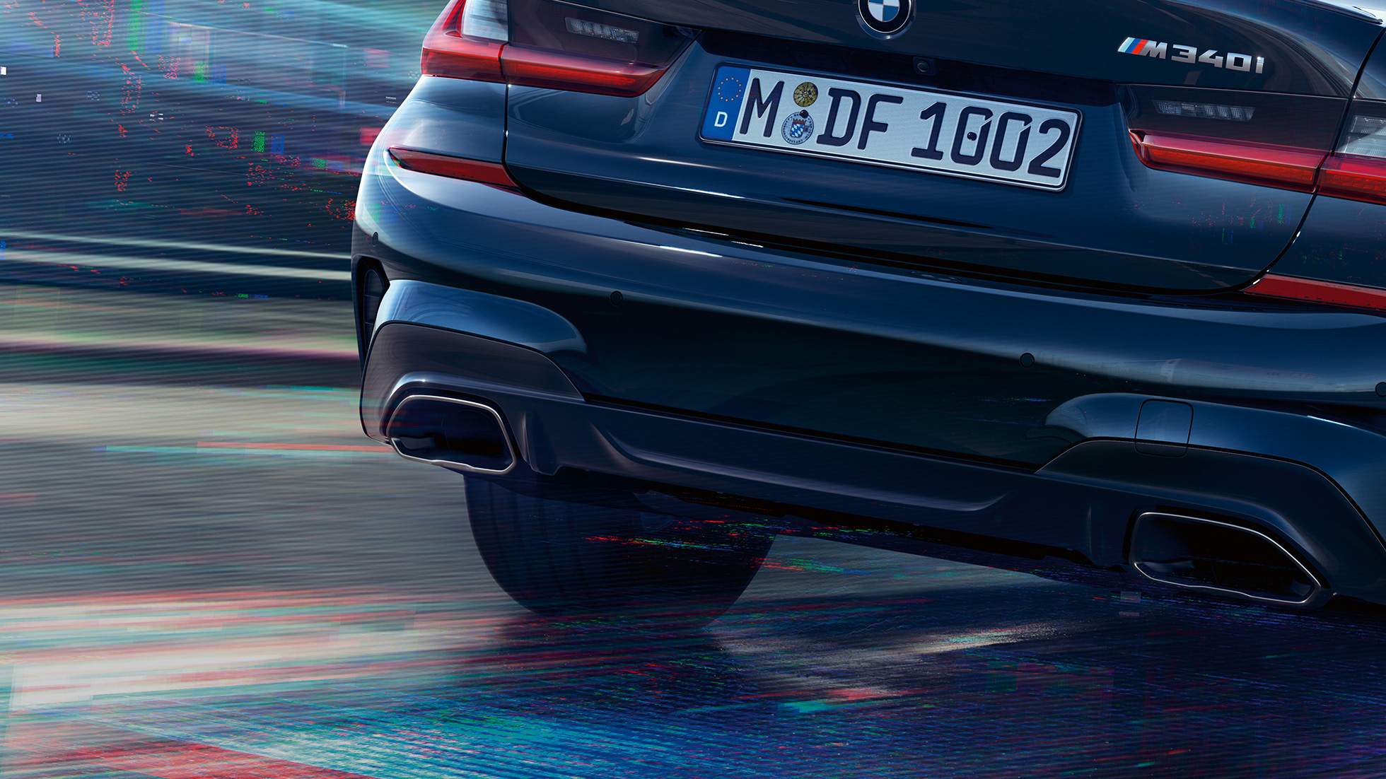 M enderørsdeksler på BMW 3-serie Sedan. Nærbilde av hekken på BMW 3-serie Sedan med spesielle M enderørsdeksler i ceriumgrå metallic.