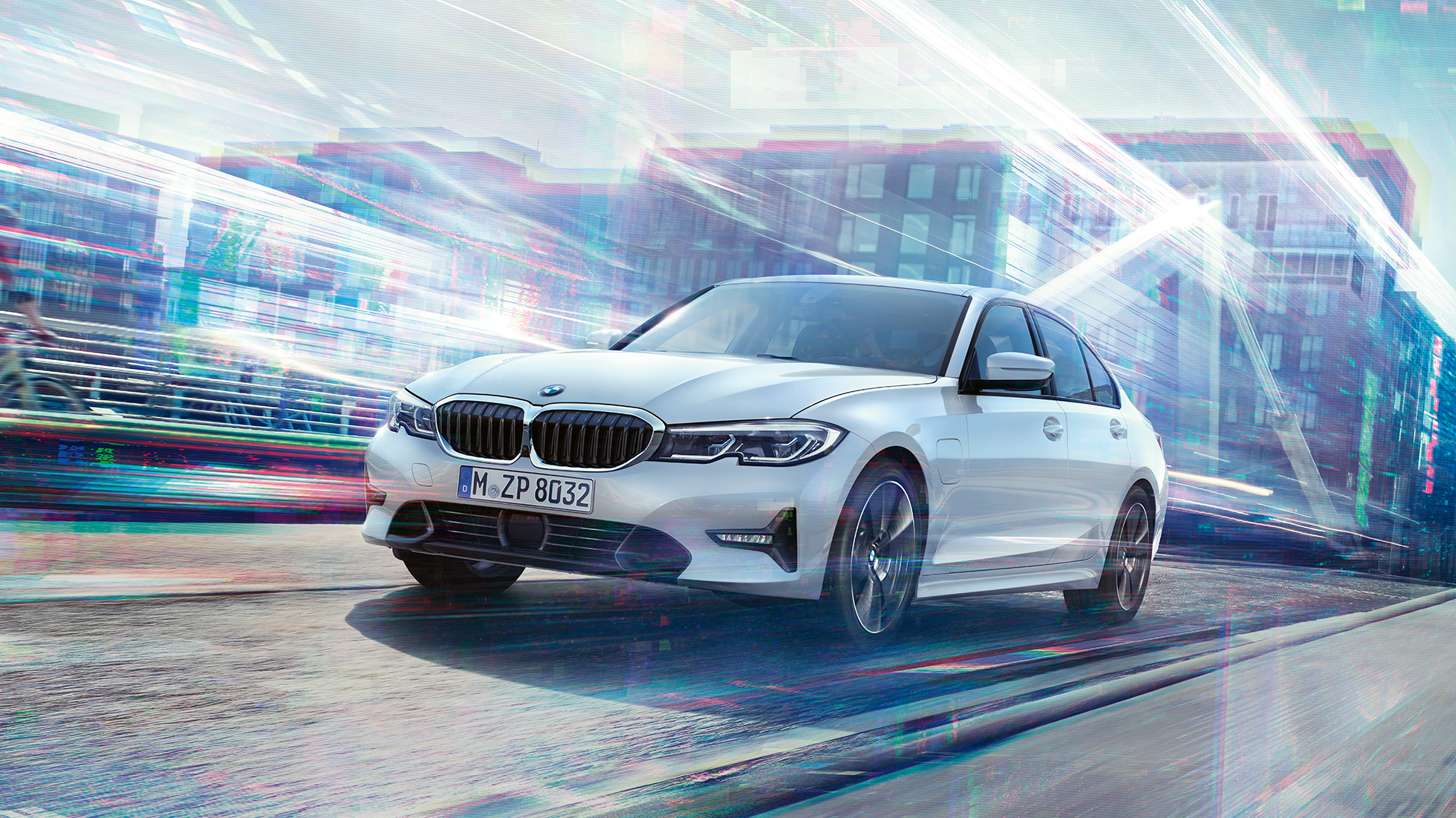 BMW 3-serie Sedan 330e på farten. BMW 3-serie Sedan 330e som kjører foran bylandskap.