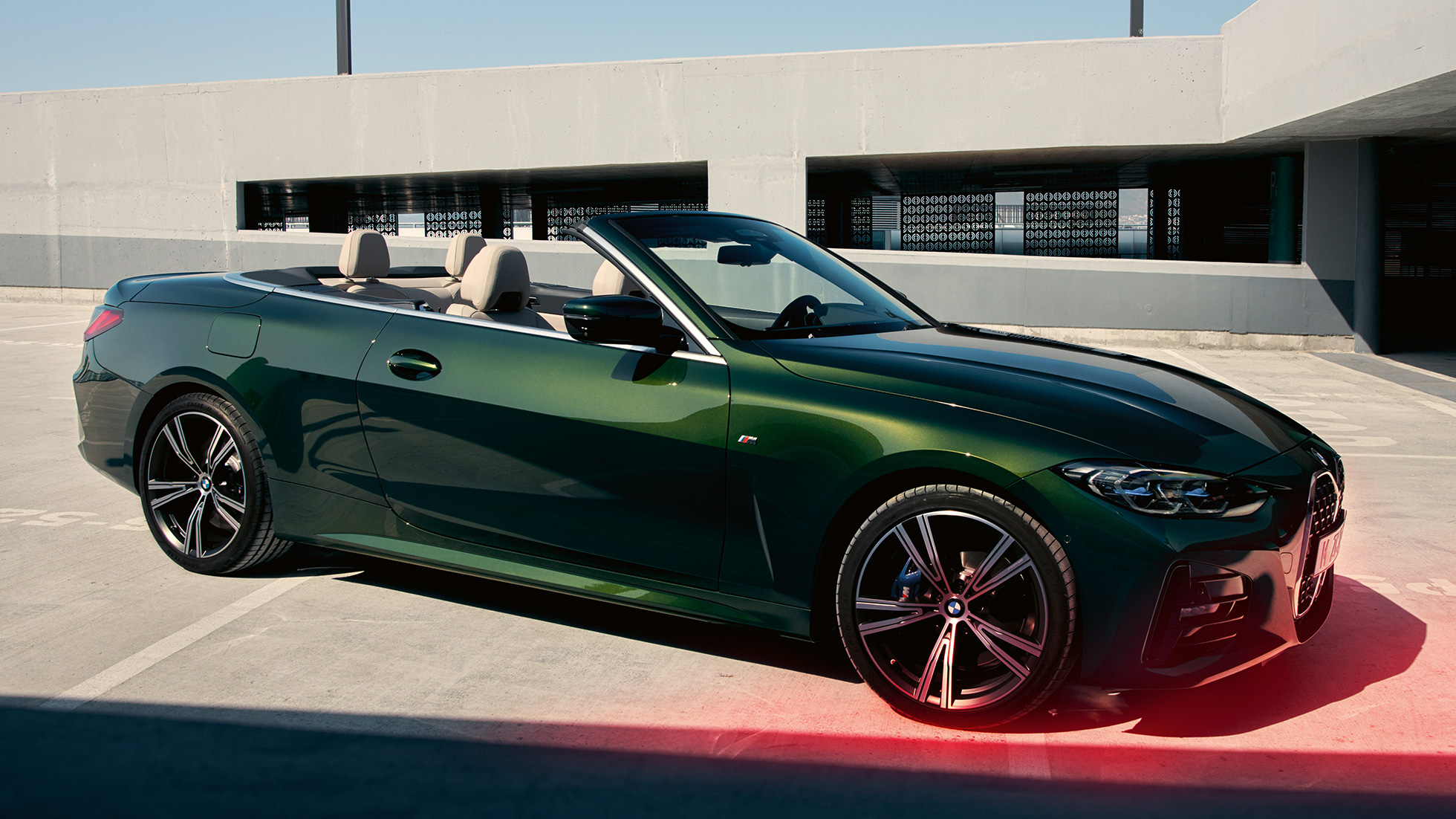 Sett skrått forfra BMW 4-serie Cabriolet G23 2020 med mann BMW 4-serie Cabriolet G23 2020 Sanremo grønn metallic Sett skrått forfra med mann ved siden av