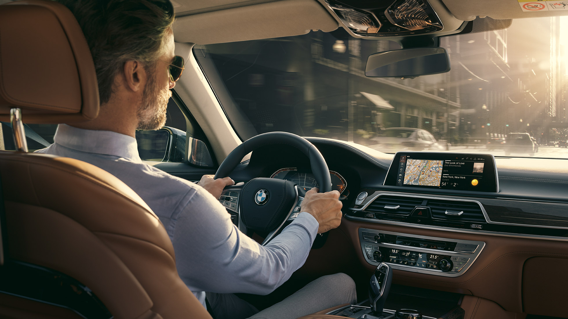 Connectivity-funksjoner i BMW 7-serie Sedan BMW 7-serie Sedan: Mann sitter i BMW og bruker Connectivity-funksjoner