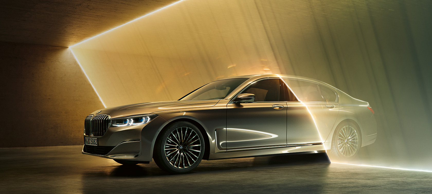 BMW 7-serie sedan, luksuslimousin, sett skrått forfra BMW 7-serie sedan, luksuslimousin: Grå BMW omgitt av lysstråler sett skrått forfra