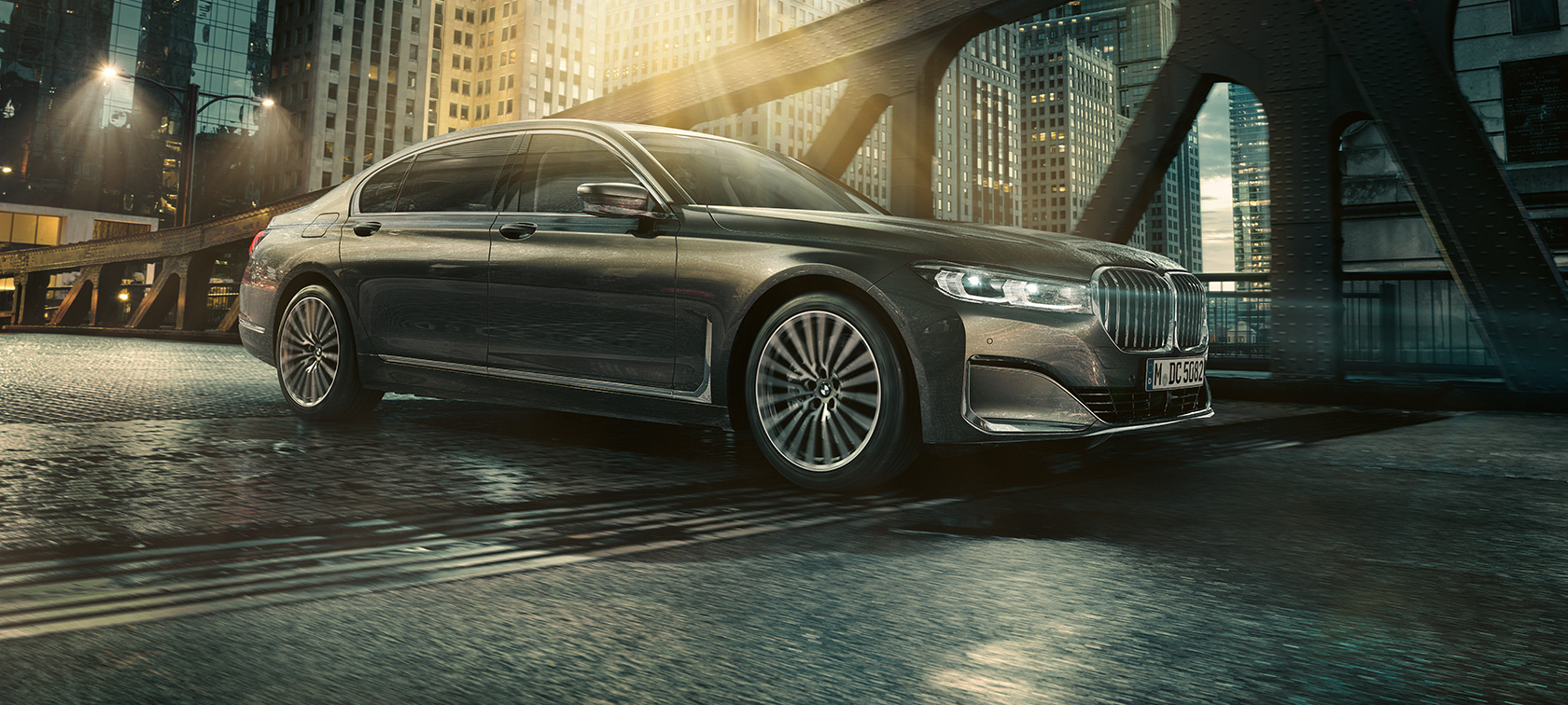BMW 7-serie Sedan, sett fra siden BMW 7-serie Sedan står med åpen dør foran belyst hotell, sett fra siden