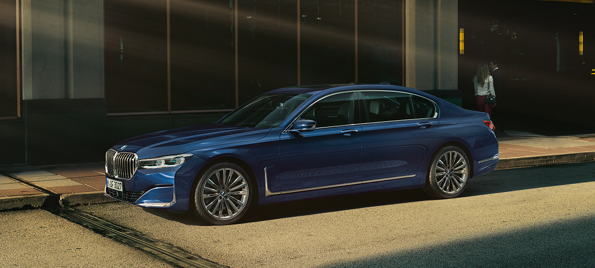 BMW Individual 7-serie Sedan, sett fra siden Rød BMW Individual 7-serie Sedan sett fra siden i bylandskap