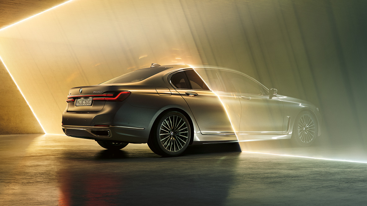 Berninagrå BMW 7-serie Sedan: Berninagrå BMW 7-serie Sedan omgitt av lysstråle sett skrått bakfra