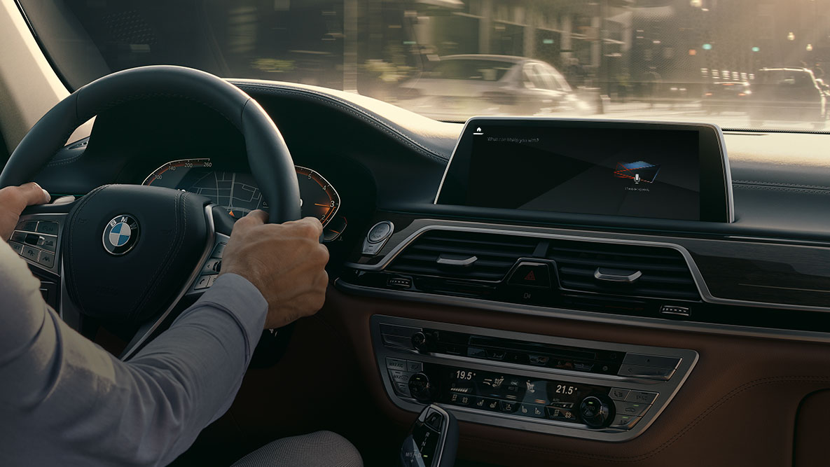 BMW Intelligent Personal Assistant BMW Intelligent Personal Assistant: Mann kjører i BMW, nærbilde av Live Cockpit Professional
