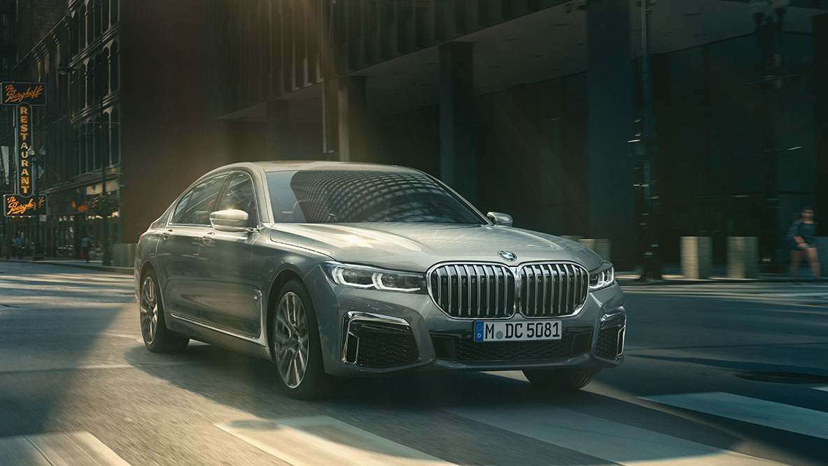 Driving Assistant Professional: BMW 7-serie Sedan som kjører i bylandskap, sett skrått forfra BMW 7-serie Sedan med Driving Assistant Professional