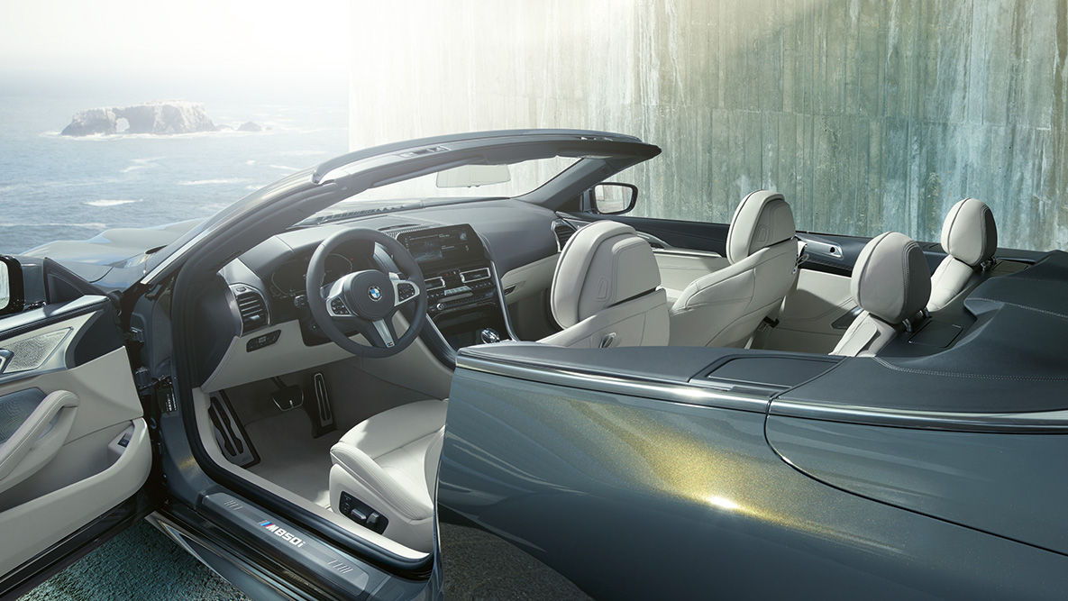 Innvendig design i BMW M850i xDrive i dravittgrå metalliclakk med stoffkalesje og åpen dør. Innvendig design i BMW M850i xDrive i dravittgrå metalliclakk med stoffkalesje og åpen dør.
