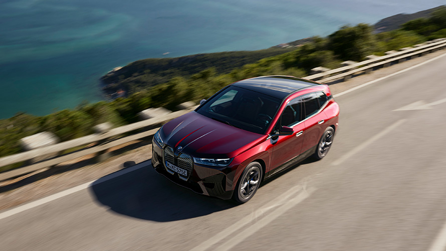 BMW iX i20 elektrisk SUV BMW iX xDrive50 Performance BMW iX i20 2021 elektrisk SUV BMW iX xDrive50 Aventurinrød kjørende på veien Performance