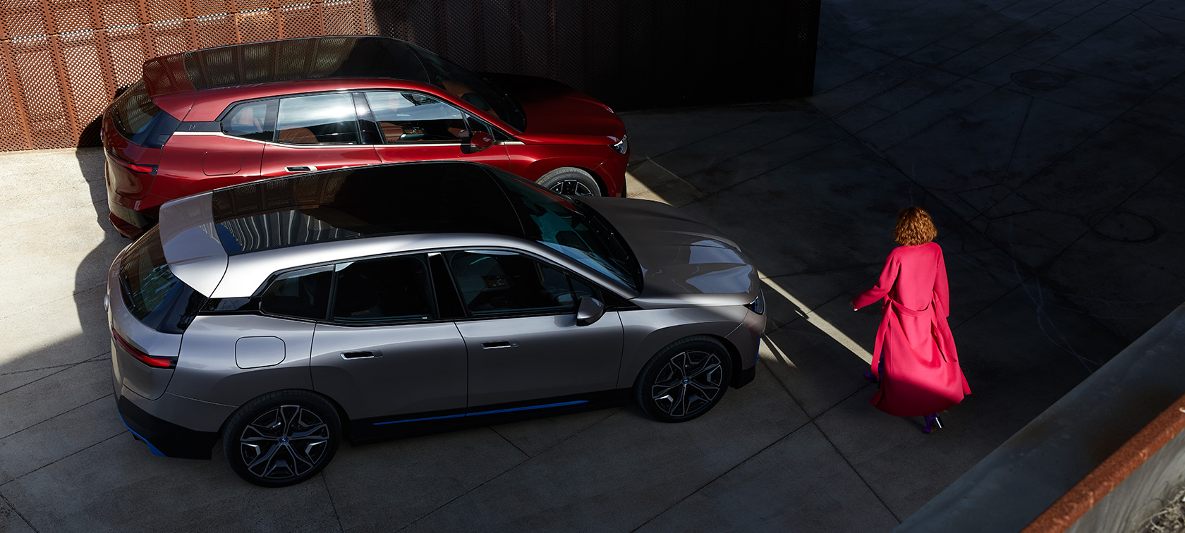 BMW iX fugleperspektiv med modell BMW iX aventurinrød og kashmirsølv i20 fugleperspektiv med modell