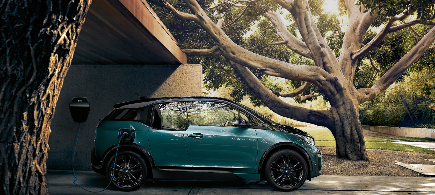 BMW i3 2018 sett forfra BMW i3 I01 2018 Jucarobeige med detaljer i frostgrå metallic sett forfra kjørende i bylandskap
