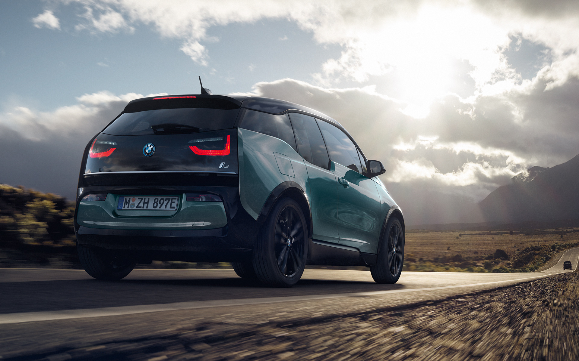 BMW i3 I01 2018 Blue Ridge Mountain med detaljer i frostgrå metallic sett skrått bakfra kjørende på landevei