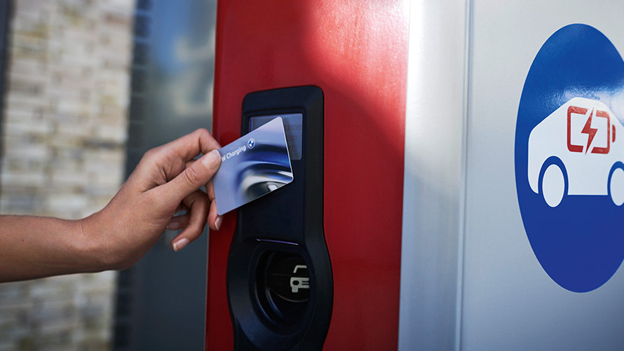 Person holder BMW Charging Card ved offentlig ladestasjon Person holder BMW Charging Card ved offentlig ladestasjon