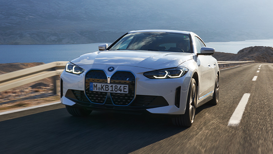 Sett skrått forfra BMW i4 eDrive40 G26 2021 kjørende BMW i4 eDrive40 G26 2021 Mineralhvit Sett skrått forfra kjørende