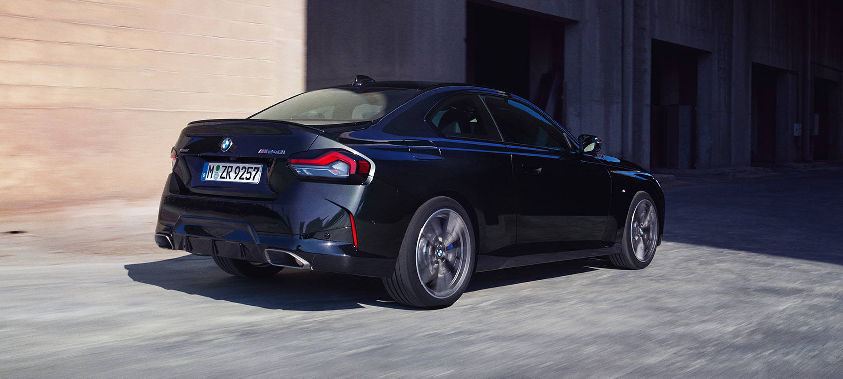 Sett skrått bakfra BMW M240i xDrive Coupé G42 2021 BMW M240i xDrive Coupé G42 2021 safirsort metallic sett skrått bakfra kjørende