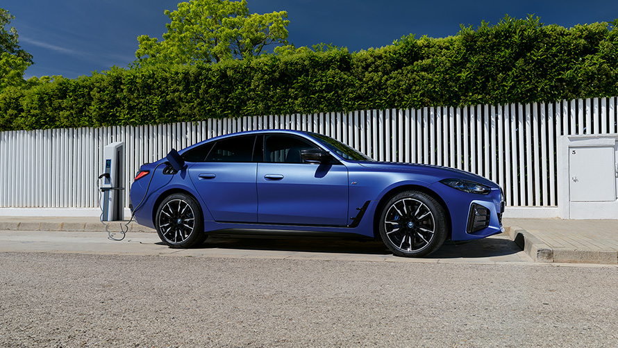 BMW i4 M50 G26 2021 BMW Individual frostet Portimaoblå metallic sett fra siden tilkoblet ladesøyle