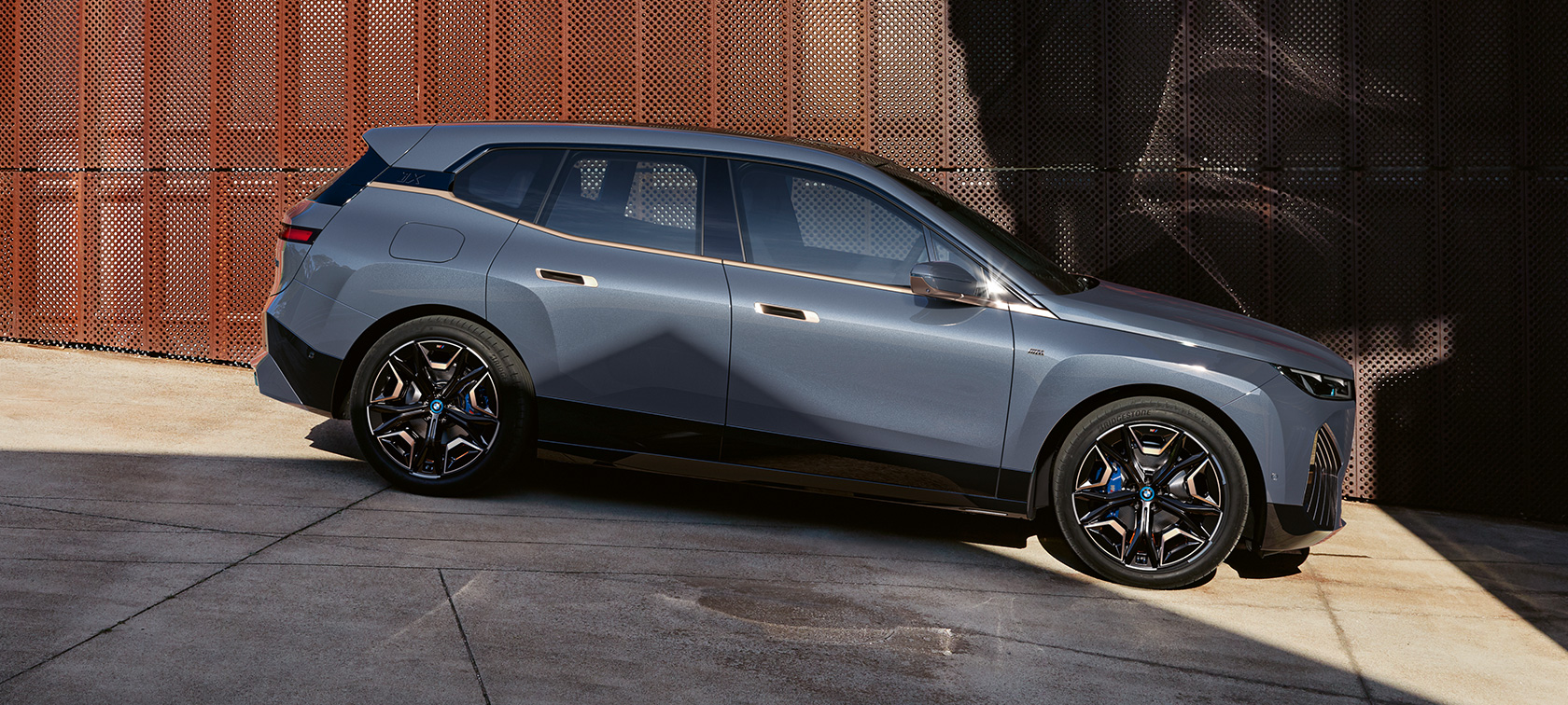 BMW iX M60 i20 2022 elektrisk SUV elbil Oksidgrå metallic sett fra siden under parkering