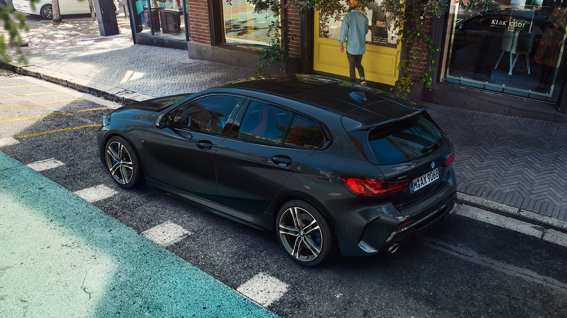 BMW M135i xDrive, parkert. BMW M135i xDrive i safirsort metallic, skrått fra siden i fugleperspektiv, parkert.