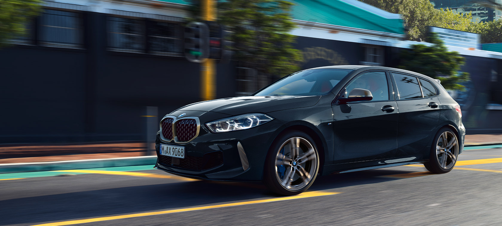 BMW 1-serie M135i xDrive (F40) i safirsort metallic, kj&oslash;rende i urbane omgivelser
